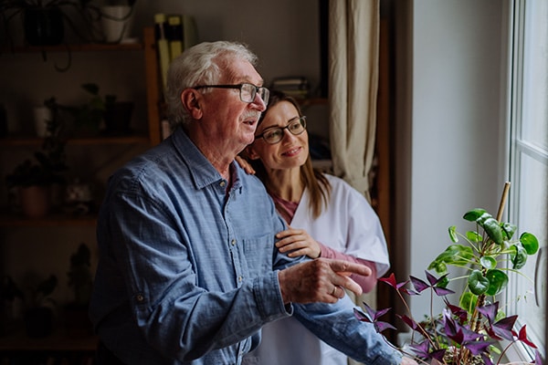 Younger woman and older man looking out a window