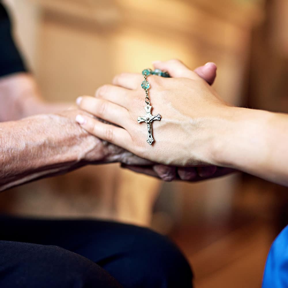 Hands clasped with cross