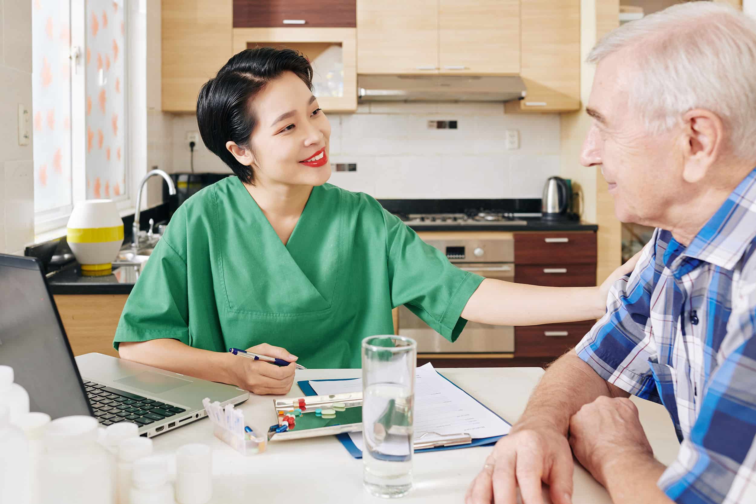Nurse with man at kitchen table