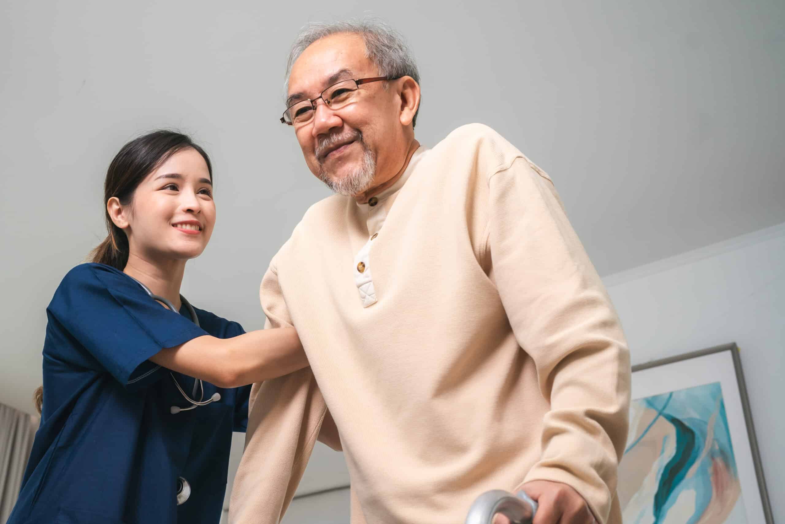 Asian physiotherapist nursing home to support old senior man patient therapy by walker