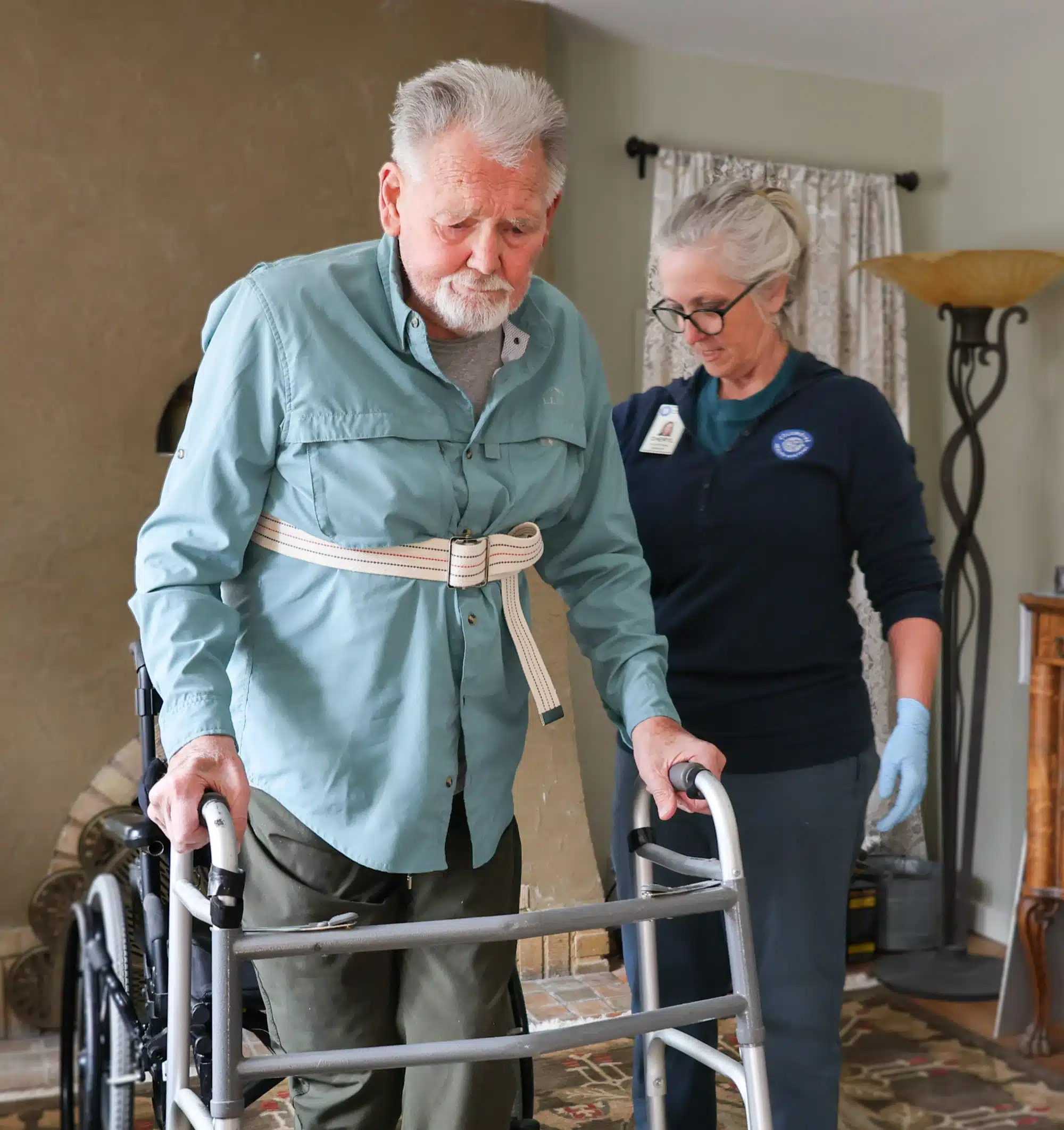 Man using a walker with a nurse helping him